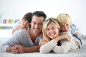 Portrait of happy family laying on carpet